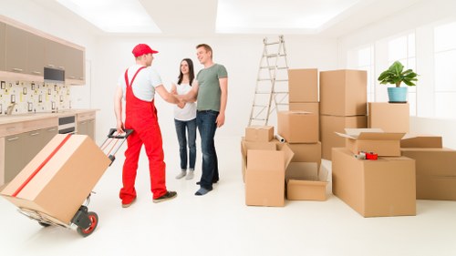 Professional movers carrying items through a central London apartment building